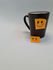 Smiling and frowning faces on a cup
