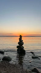 Tuinposter stack of stones on the sunset beach © Valentyn