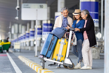 Group of Asian family tourist passenger with senior is using mobile application to call pick up taxi at airport terminal for transportation during their vacation travel and long weekend holiday