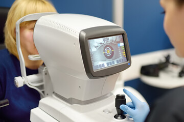 Patient during visit to optometrist for microscopic analysis of eyelids, sclera, conjunctiva, iris,...