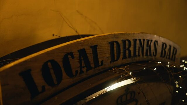 Wooden sign displaying local drinks bar hanging on wall
