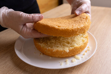 The freshly baked cake is cut in half for the filling. Cake making.