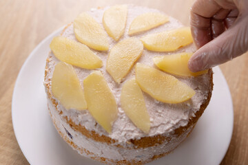 The cake is decorated with slices of pear. Making cakes.