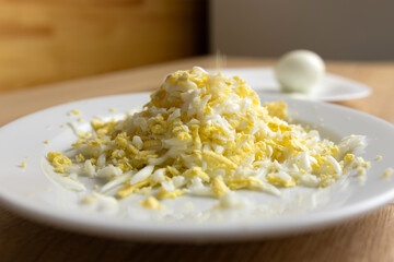 Grate the boiled egg on a plate.