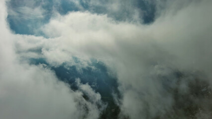 Obraz premium Flying through clouds between mountains