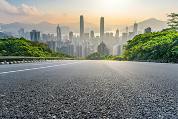 Asphalt road and mountain with city skyline scenery.