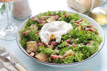 A bowl with salad lyonnaise served for lunch	