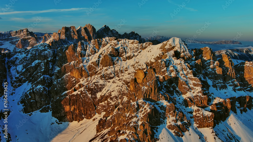 Wall mural Rocky snow mountains at sunrise aerial