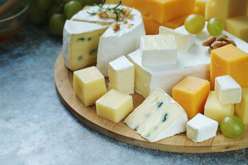 Several types of cheese served with honey and grapes	