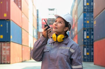 Industrial Asian female engineer checking containers using walkie talkie in front of container cargo freight ship for container loading. - 760678490