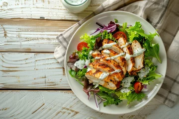 Gordijnen Grilled Chicken Salad with Ranch Dressing on a Wooden Table © JJAVA
