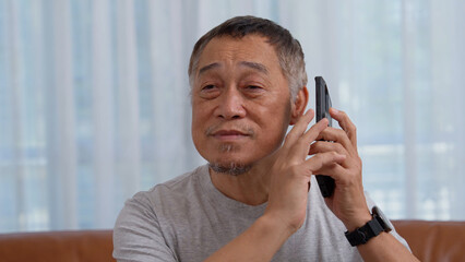 Blind Asian elderly men use digital assistant get ease of access functions on smartphone, Voice...