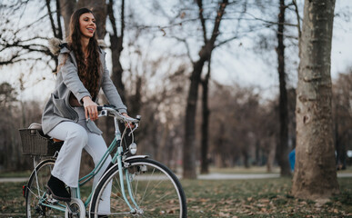 Fototapeta premium Elegant businesswoman with a stylish bicycle taking a break in a tranquil park setting