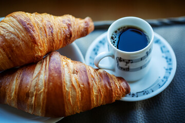 Cup of coffee with two croissants