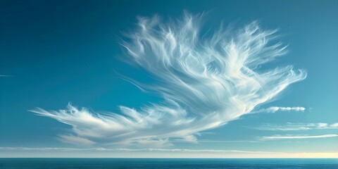 A delicate cloud drifts across a clear blue sky. Concept Clouds, Sky, Nature, Weather, Beauty - obrazy, fototapety, plakaty