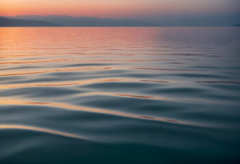 Fototapeta premium A gently undulating ocean surface at sunset, with soft ripples creating a calming pattern 