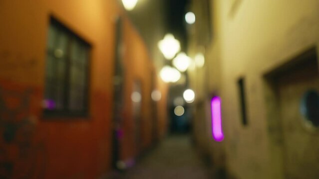 Nighttime Atmosphere: Defocused View of Dark Alley with Wall Lighting at Midnight
