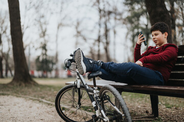 A casual day at the park capturing a young boy having a break on a bench with his bicycle, engaging...