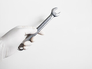 Man's hand with gloves holds a spanners isolated on white background. Mechanical tools concept.