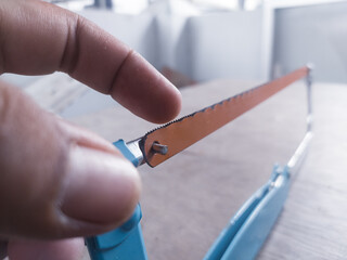 Checking sharpness and showing the correct direction of the hacksaw teeth.