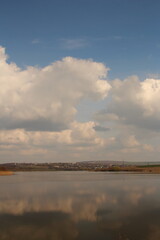 Obraz premium A body of water with clouds in the sky