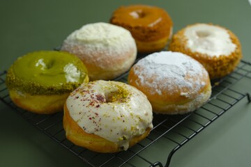 Assorted doughnuts on green background . Donat