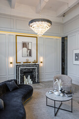 modern living room in a historical style with a marble fireplace in a chic expensive bright interior of a huge apartment without people daytime