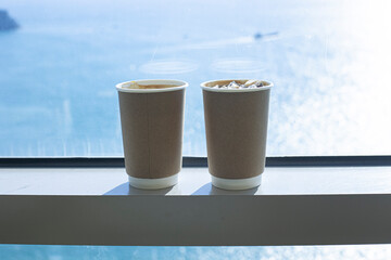 Two cups of coffee at window overlooking the sea