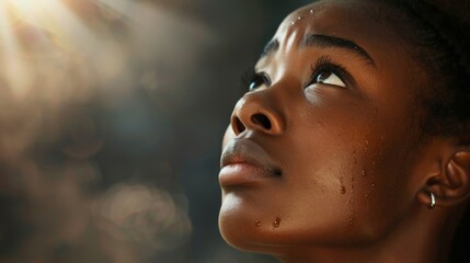 Touched by His Grace. Beautiful young black woman looking up with tears in her eyes. - obrazy, fototapety, plakaty