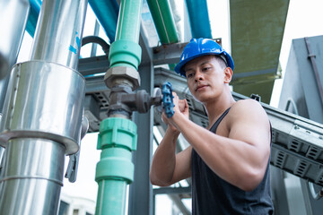 Worker Adjusting Valves at Industrial Pipeline