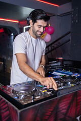 Smiling DJ Mixing Beats at Club Party