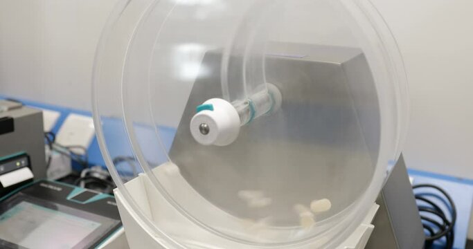 tablet dissolution test apparatus working condition close up. a scientific instrument dissolving tablets in a science instrumentation chemistry laboratory