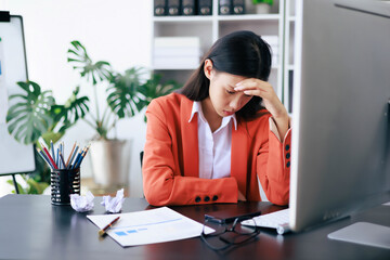 She is looking at the monitor with a sad expression on her face