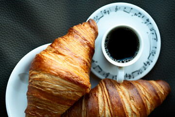 Cup of coffee with two croissants - 760729277