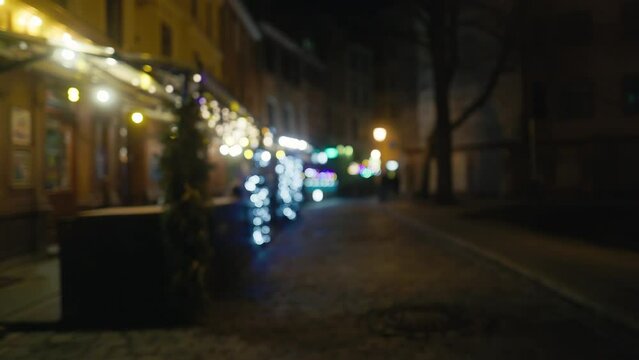 a blurry picture of a street at night with a restaurant in the background
