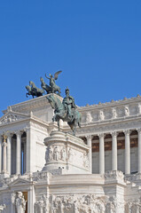 Fototapeta na wymiar Bronze statue of Vittorio Emanuele II on his horse in front of the Vittoriano or Altar of the Fatherland on Piazza Venezia (Venice Square) in Rome with blue sky