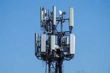 Cell phone, mobile phone telecommunication tower with antennas on blue sky