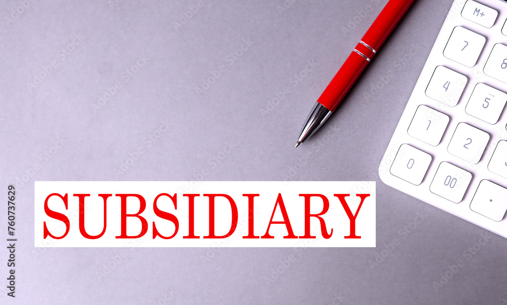 Aufkleber subsidiary text on gray background with pen and calculator