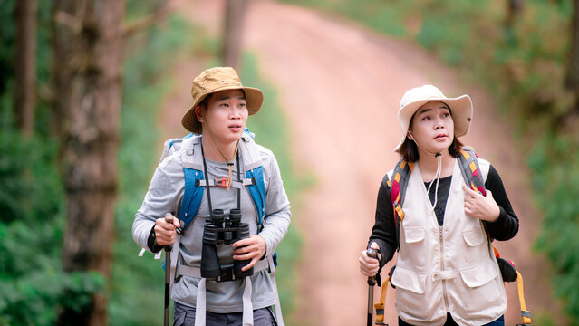 Couple of Young Happy Travelers Hiking with Backpacks on the Beautiful Rocky Trail . Family Travel and Adventure Concept.
