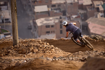 Downhill bike riders descending the lines of Morro Solar at Chorrillos With Lima city on the...