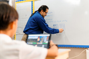 Adult Hispanic Professor Man Teacher front a Whiteboard.