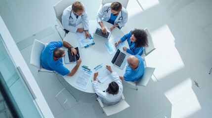 Medical team engaged in a discussion around a round table, viewed from a high angle.