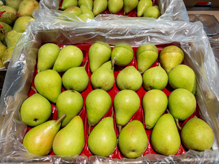 Pears displayed in a box for sale at the greengrocer's counter