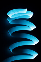 Blue neon wave of light as curls or swirl with smooth stripes on black background, vertical. Abstract background with dynamic line in motion, light painting in modern style.