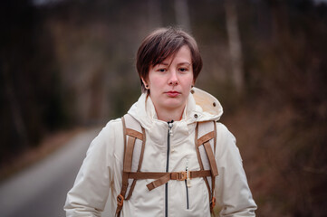 A young adult appears troubled while hiking alone on a forest path, capturing a moment of...