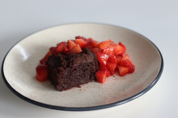 Chocolate brownies. Indulge in decadent chocolate brownies paired with fresh strawberries