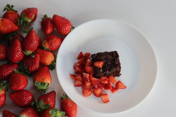Chocolate brownies. Indulge in decadent chocolate brownies paired with fresh strawberries