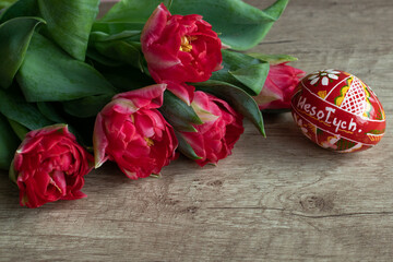 Bouquet of red jagged tulips with an Easter egg