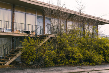 abandoned motel with overgrown trees