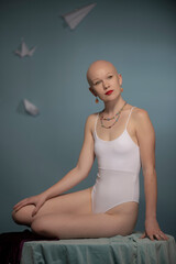 Young Los Angeles citizen poses in a studio setting wearing a white bathing suit.